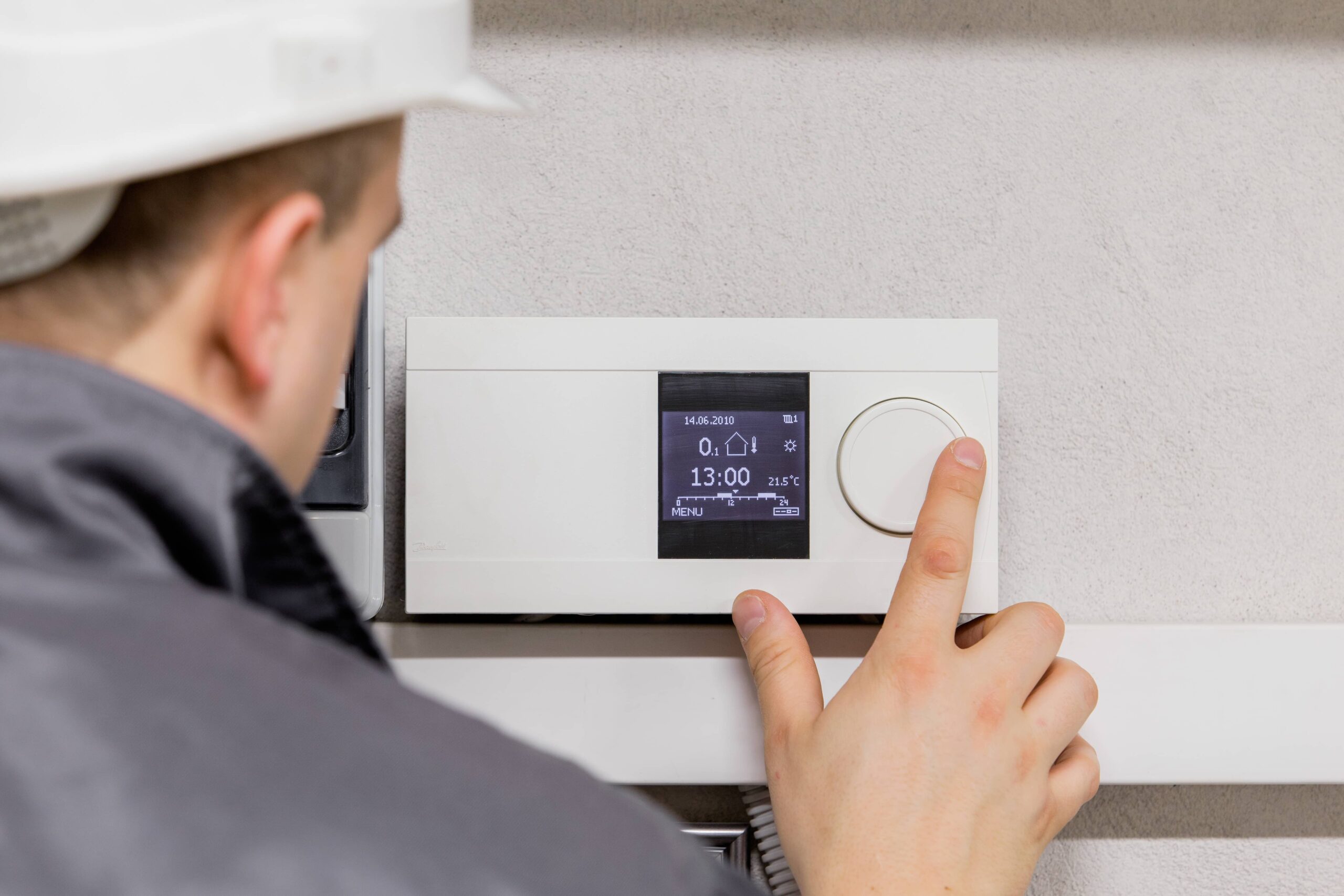 man-adjusting-thermostat-HVAC